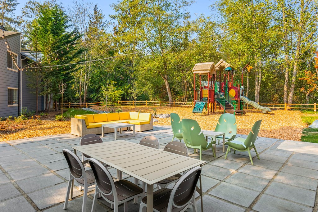 a patio with a table and chairs and a playground