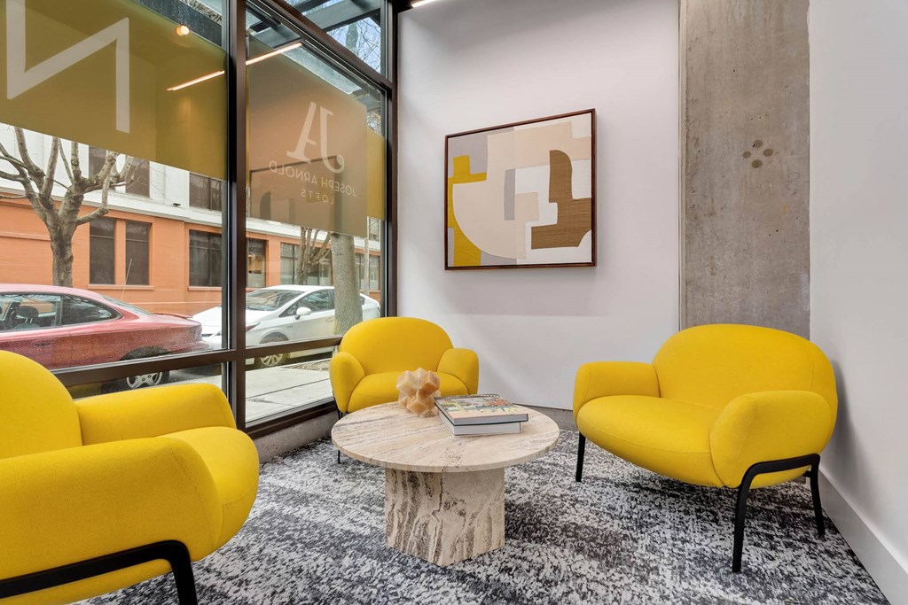 a living room with yellow chairs and a table