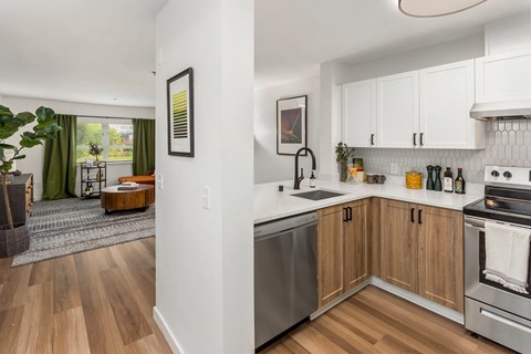 a renovated kitchen with white cabinets and stainless steel appliances