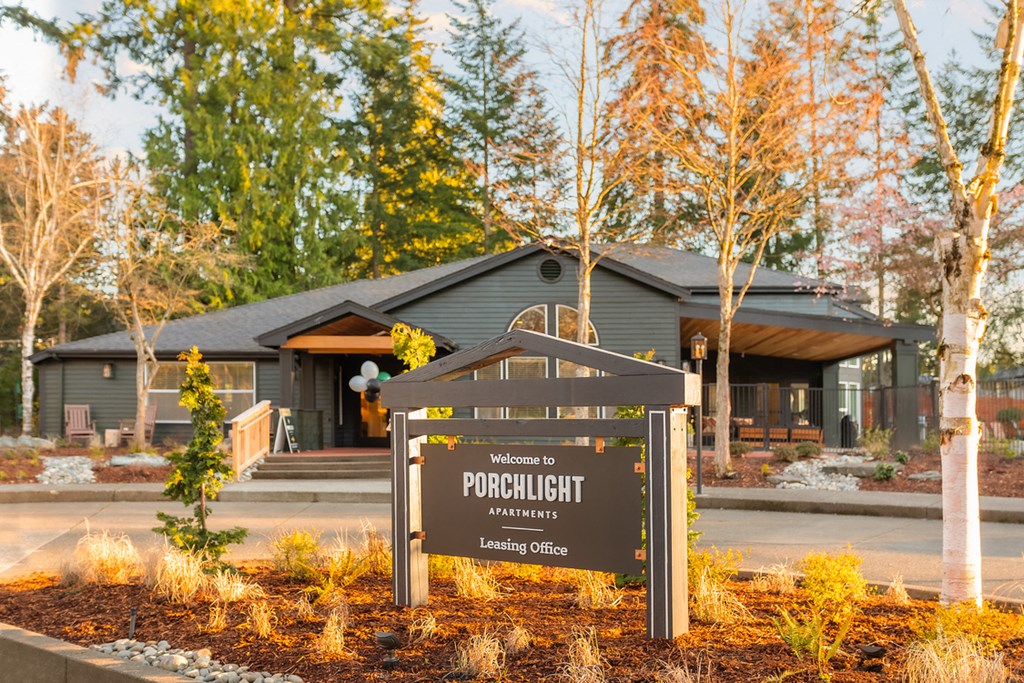 a sign in front of a house with trees