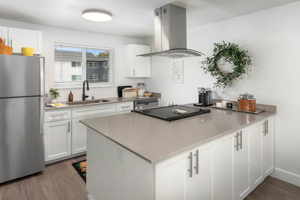 a large kitchen with white cabinets and stainless steel appliances