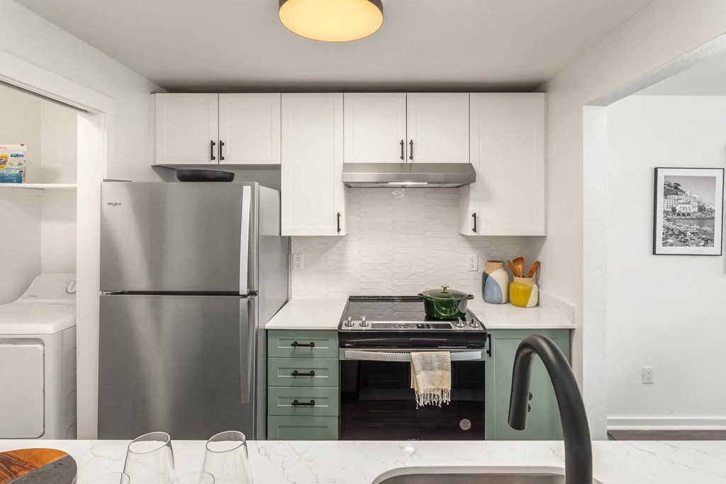 a kitchen with white cabinets and a black stove top oven