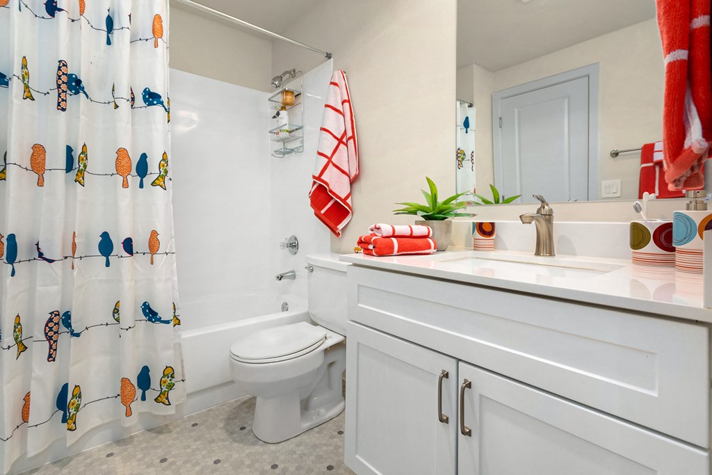 a bathroom with a shower curtain and a sink and a toilet