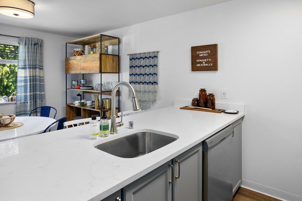 a kitchen with a sink and counter top and a window