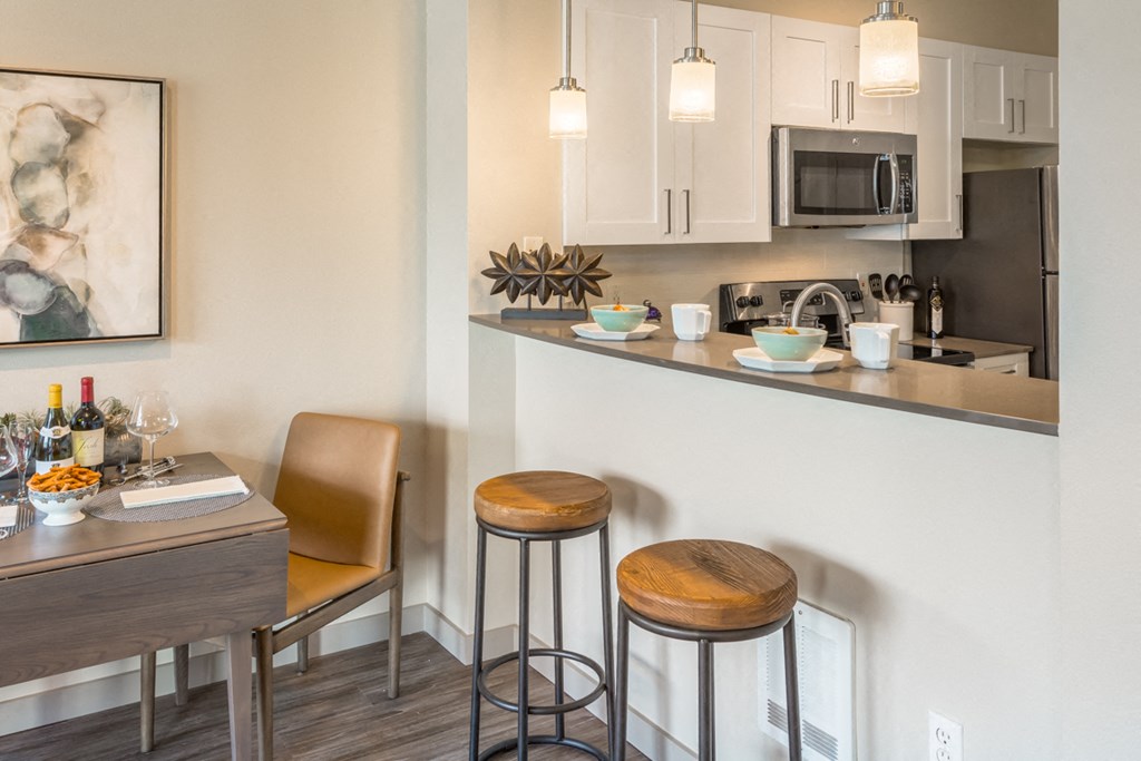 a kitchen with a bar and a dining area with stools