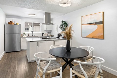 A modern kitchen with a dining table set for four.