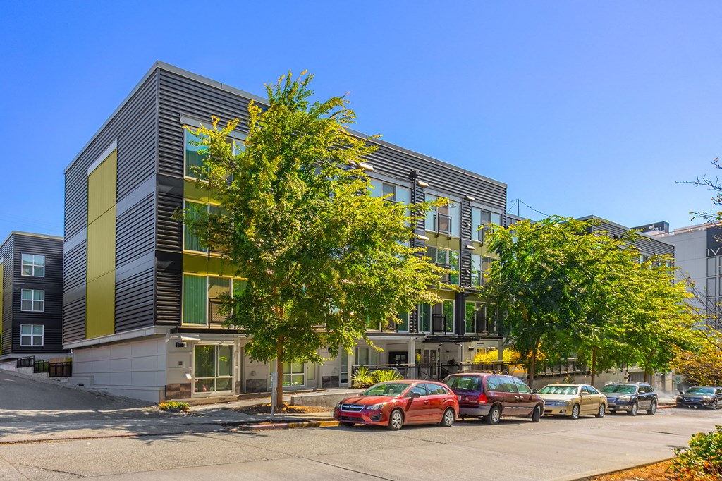 a city street with cars parked in front of a building