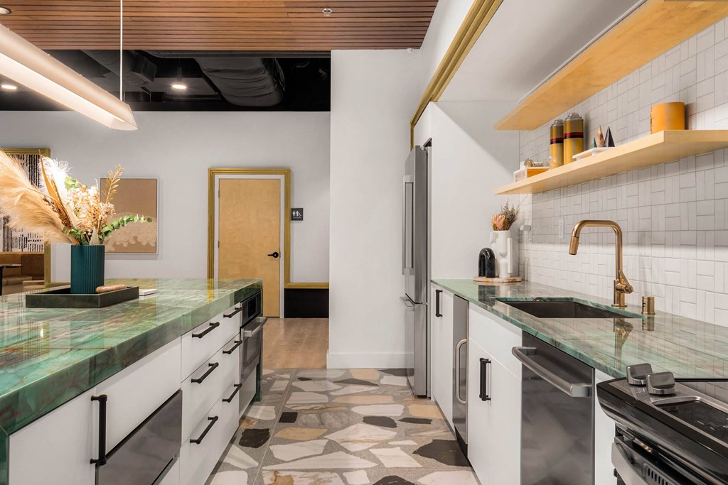 a kitchen with white cabinets and green marble counter tops