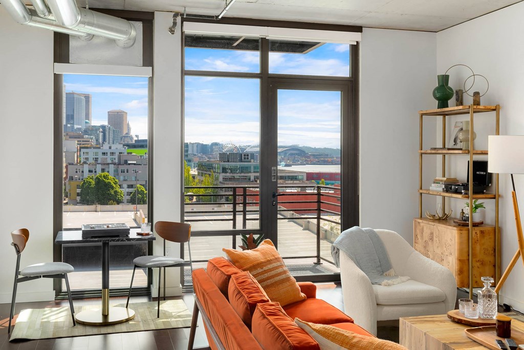 a living room with a orange couch and a view of the city