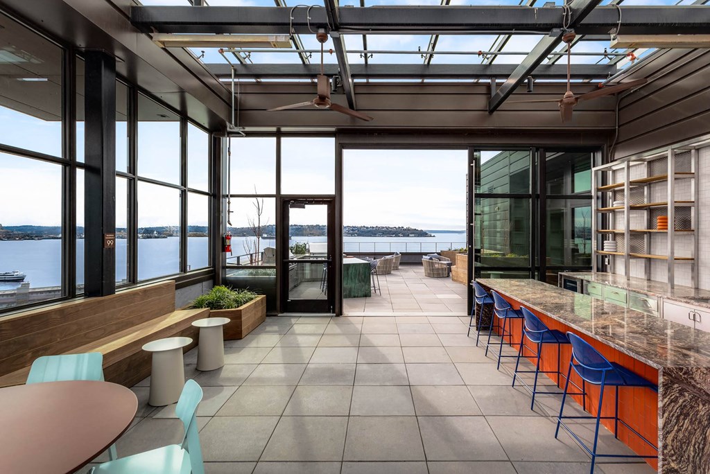 a room with a long bar and a view of the water