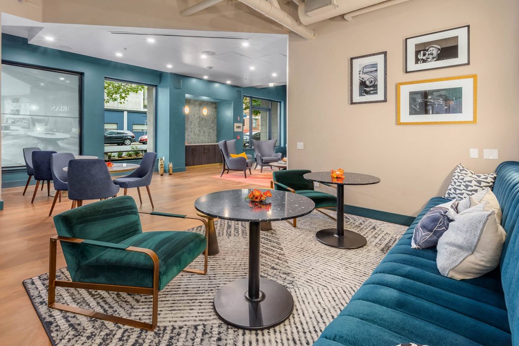 a living room with a blue couch and chairs and tables