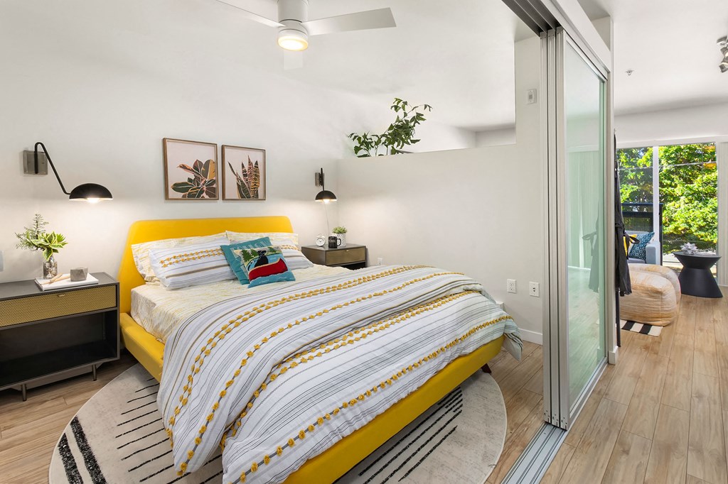 a bedroom with a yellow bed and a sliding glass door