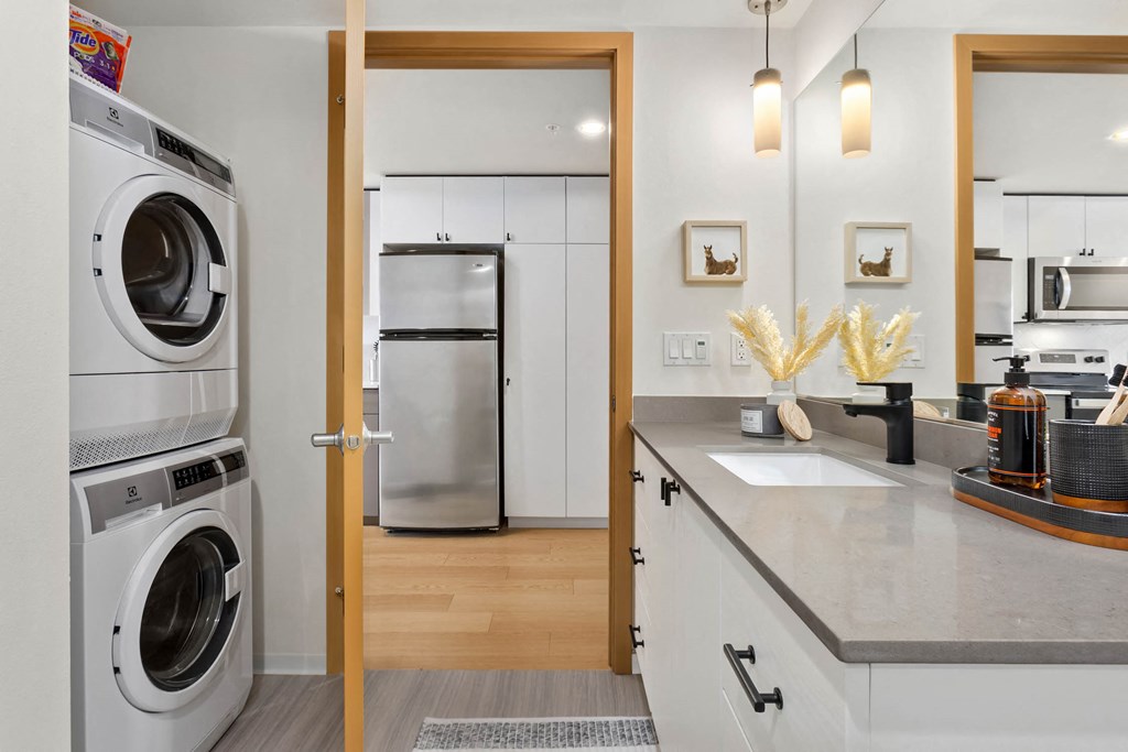 a kitchen with a washer and dryer and a door to a laundry room