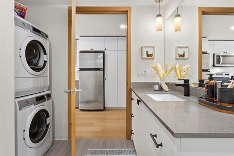 a kitchen with a washer and dryer and a door to a laundry room