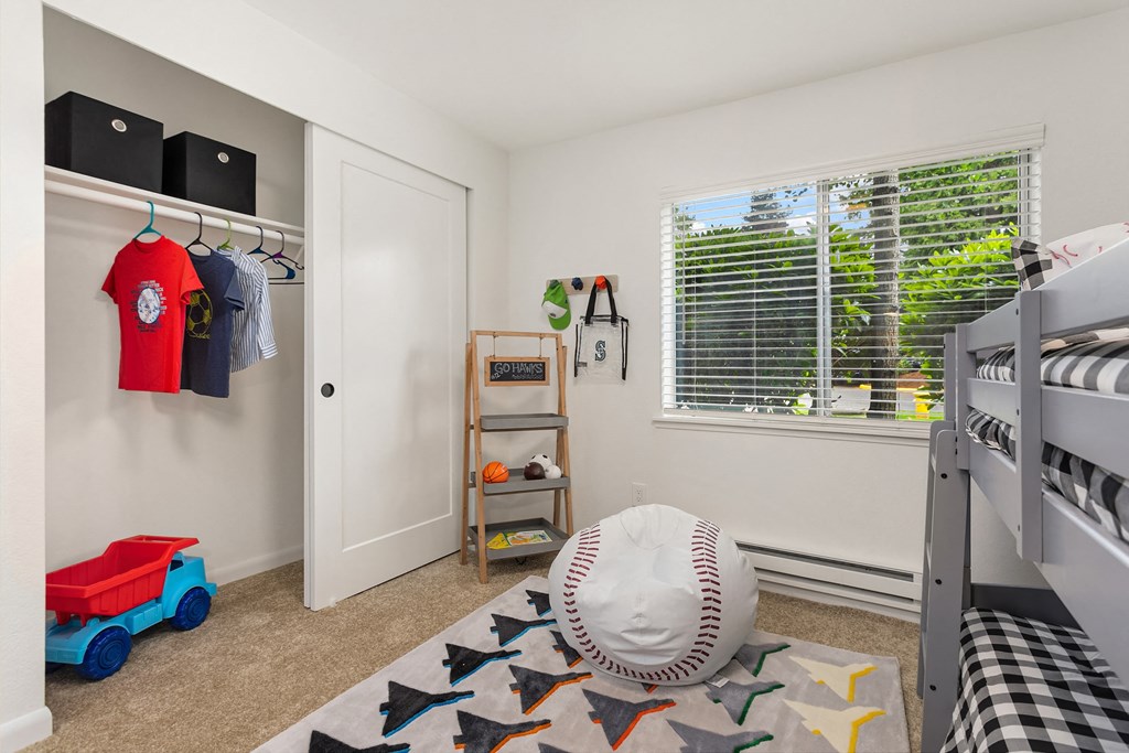 a bedroom with a bunk bed and a window with a baseball