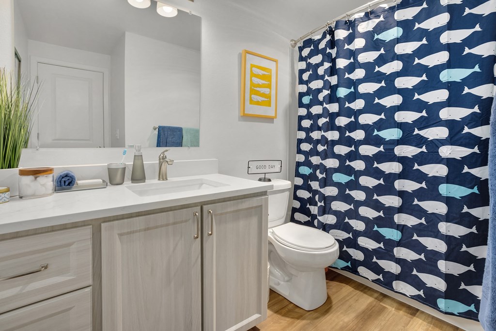 a bathroom with a shower curtain and a sink and a toilet