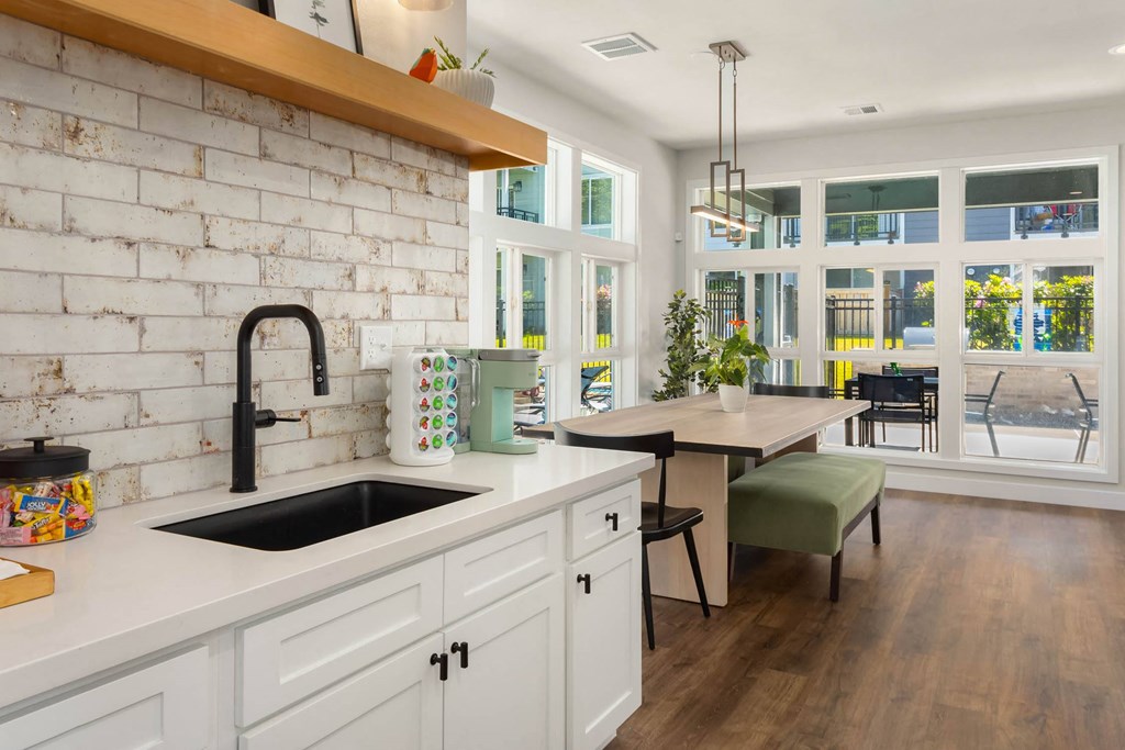 a kitchen with white cabinets and a white brick wall