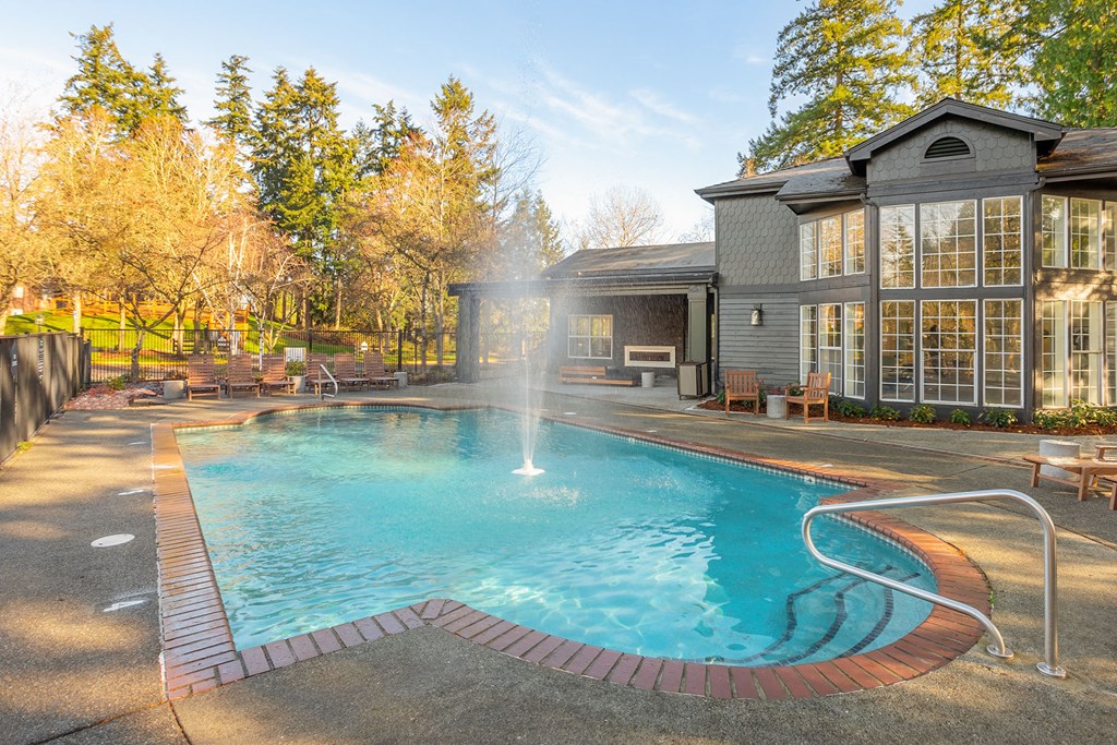a swimming pool with a fountain in front of a house