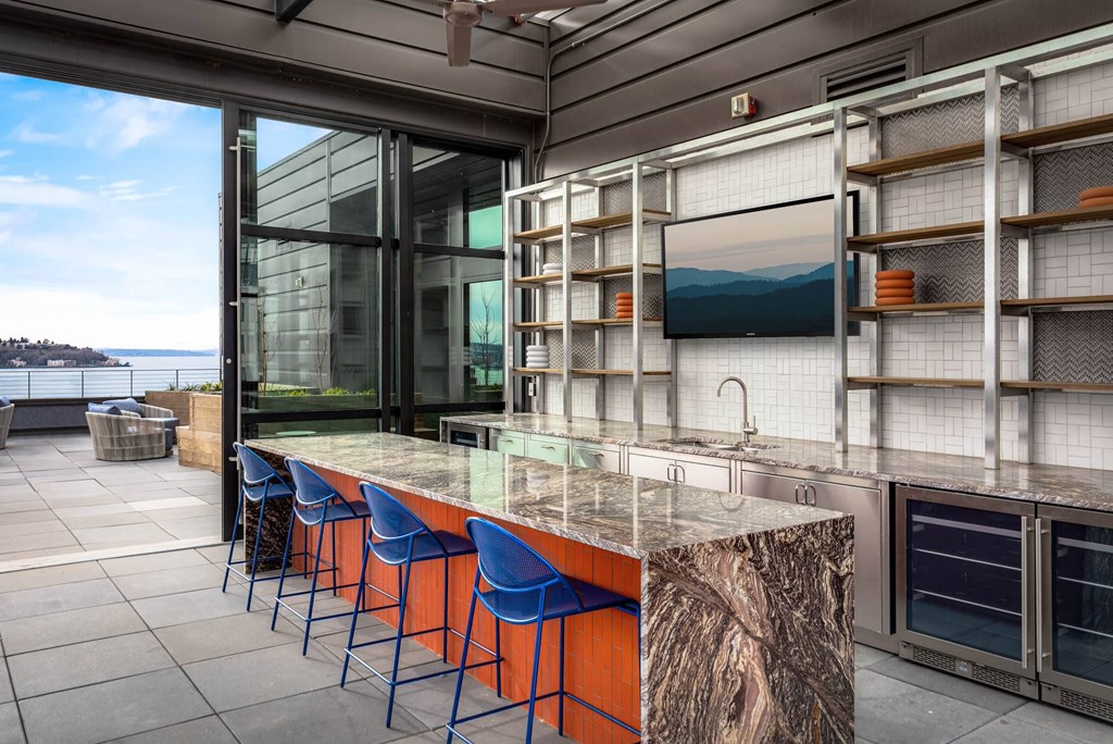 a kitchen with a marble counter top and blue chairs