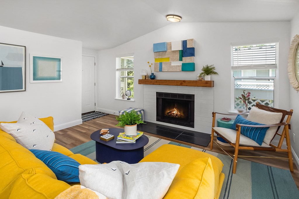 a living room with a yellow couch and a fireplace