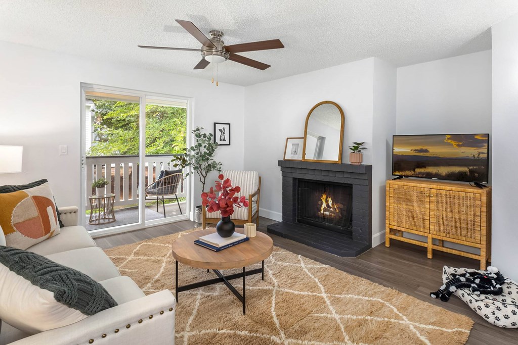 A living room with a fireplace and a painting on the wall.