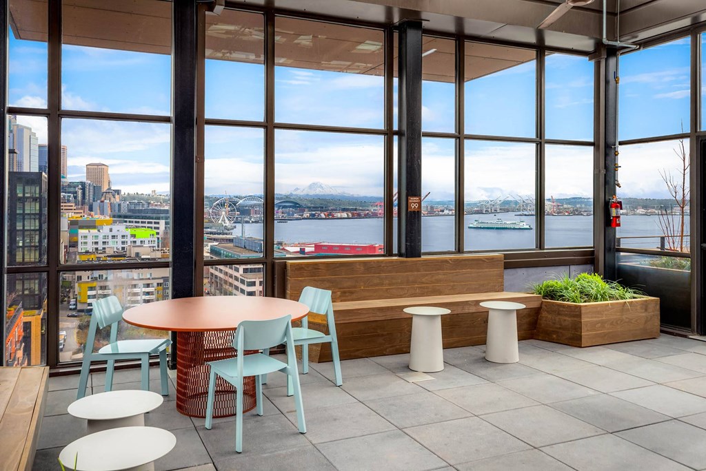 a seating area with tables and chairs in front of a window
