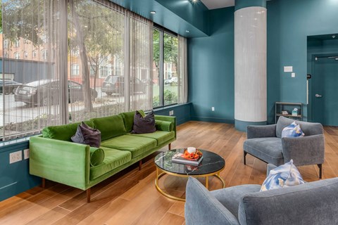 a living room with blue walls and a green couch