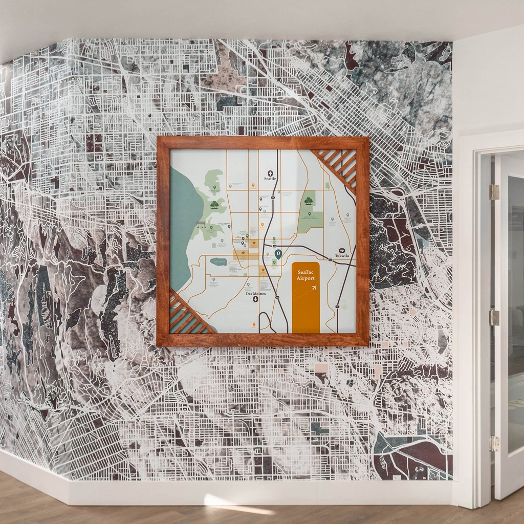 A framed map of a city is hanging on a wall with a map of a city in the background.