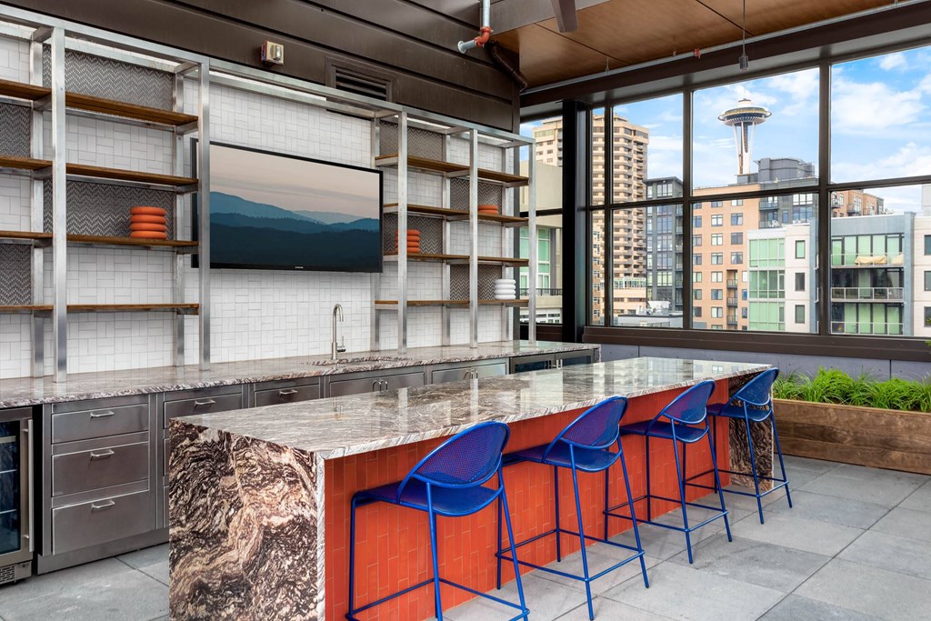a kitchen with a marble counter top and blue chairs