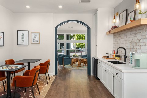a kitchen with white cabinets and an arched doorway leading to a living room