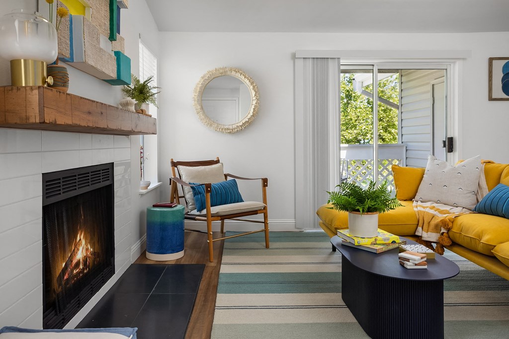a living room with a fireplace and yellow furniture