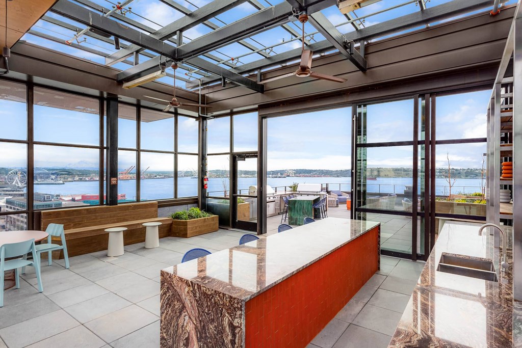 a view of the water from a room with a counter and windows