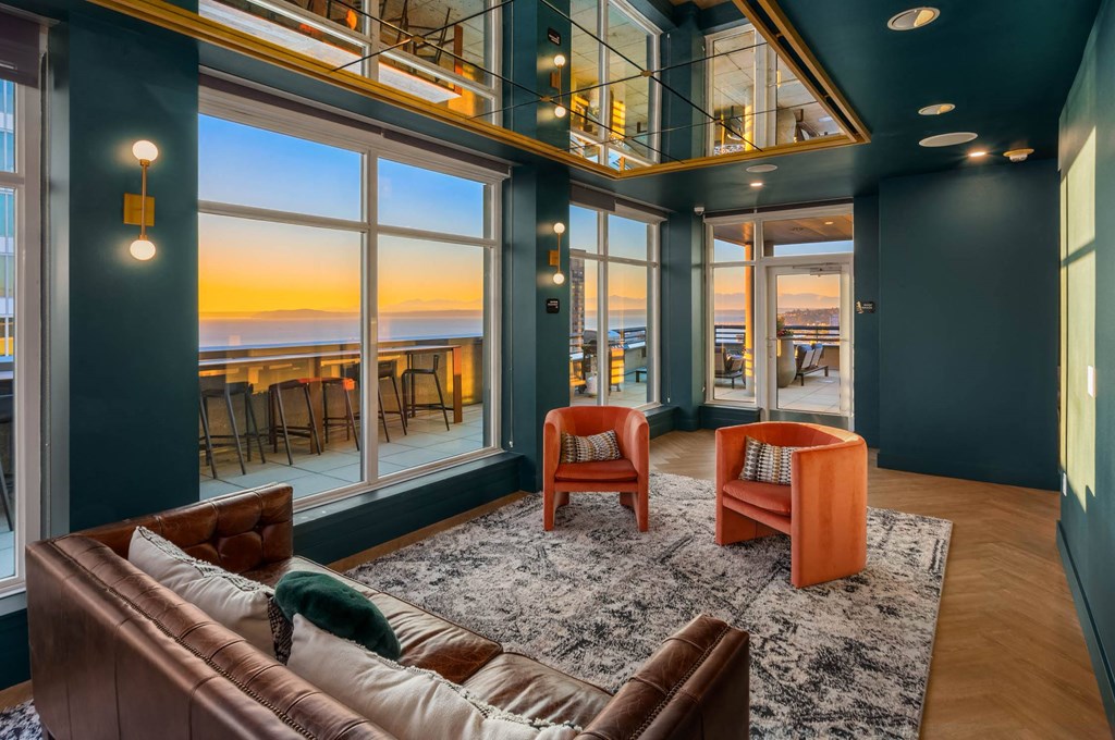 the living room has a view of the ocean and the sunset