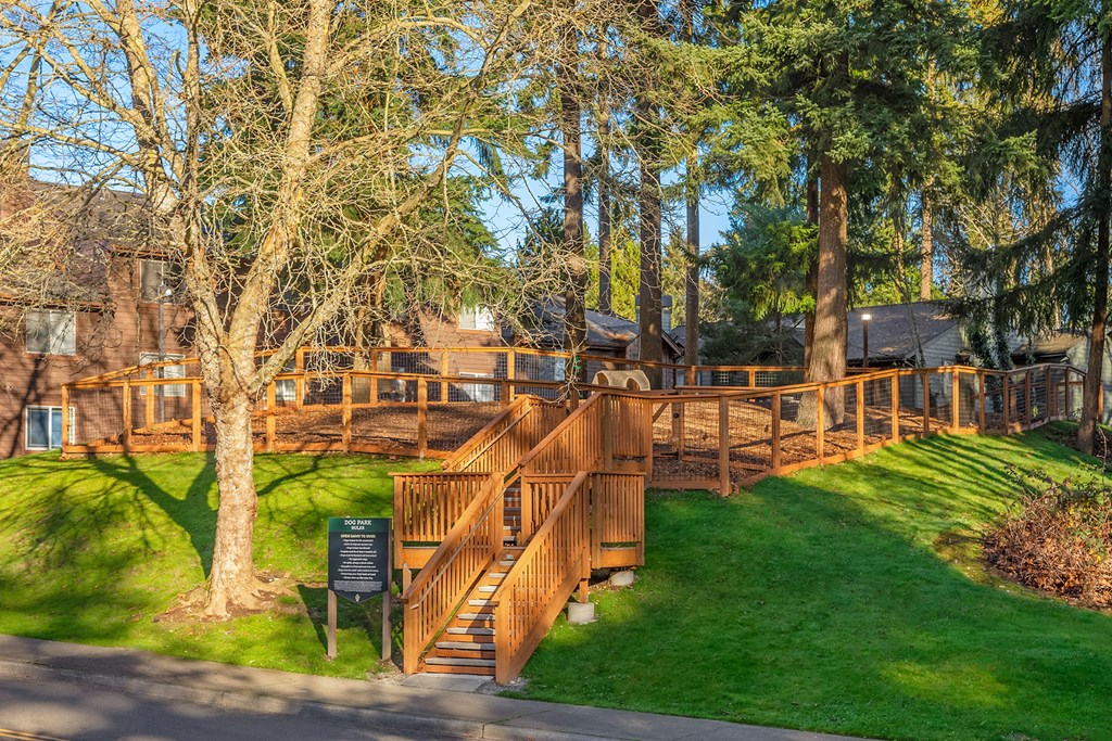 a wooden bridge in the middle of a park with trees