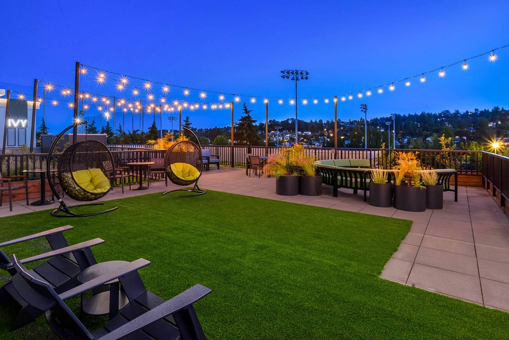 a roof top patio with chairs and a lawn