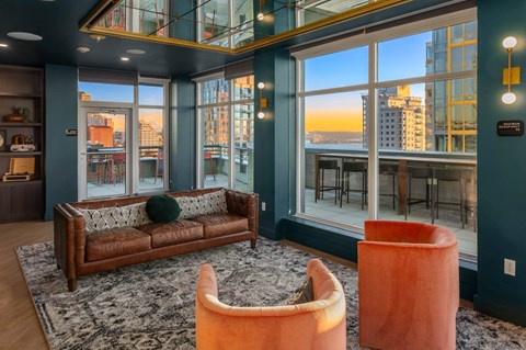 a living room with leather couches and a view of the city