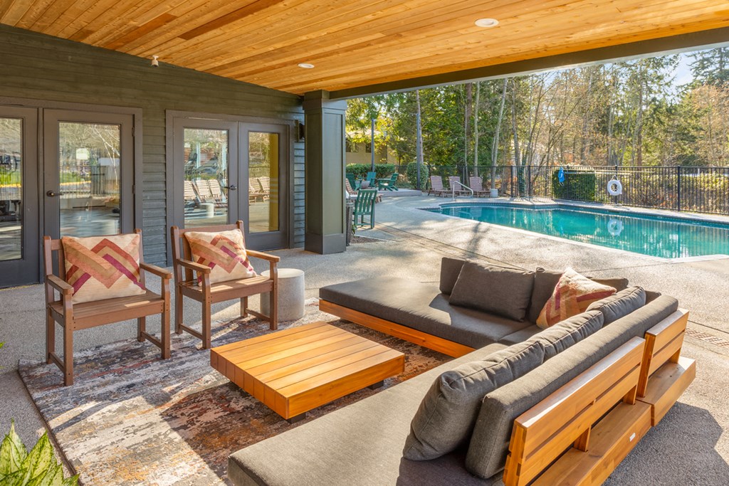 a patio with a pool and a couch and chairs