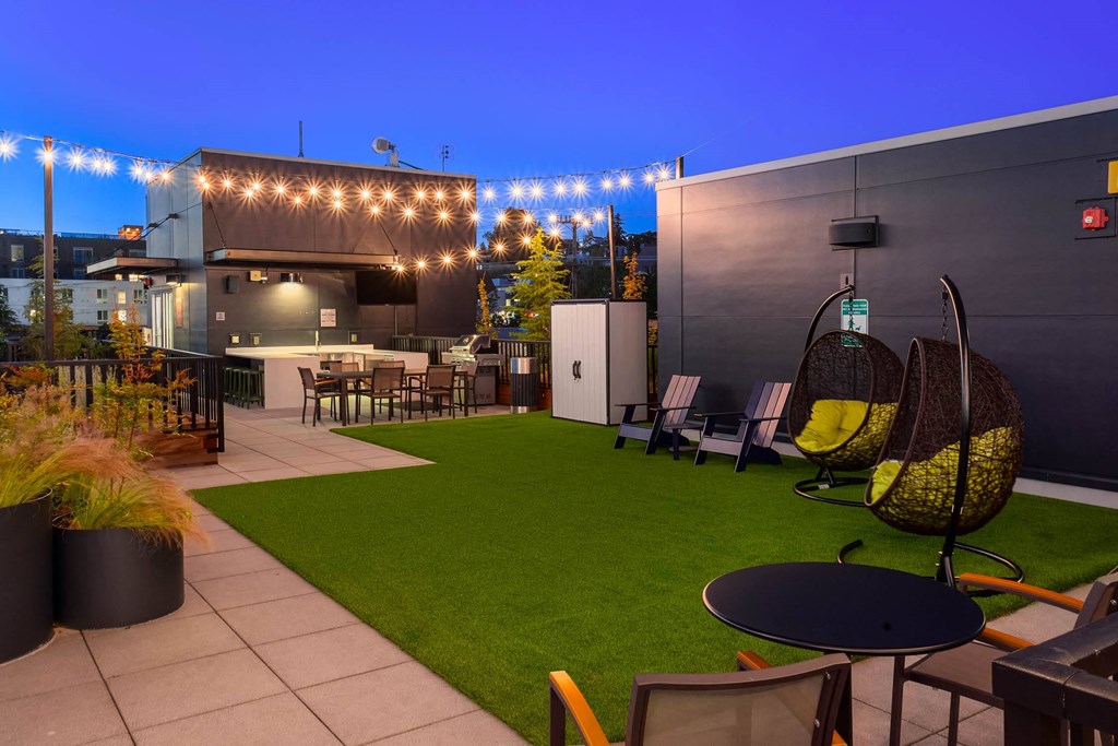 a backyard with a lawn and tables and chairs