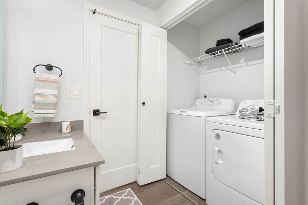 a small laundry room with a washer and dryer and a sink