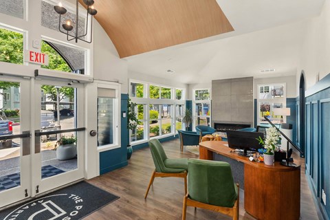 a lobby with green chairs and a table with a television on top of it