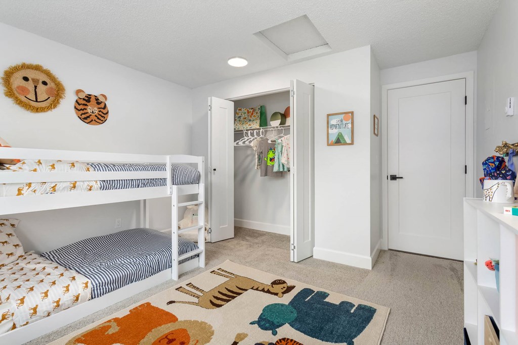 A room with bunk beds and a refrigerator.