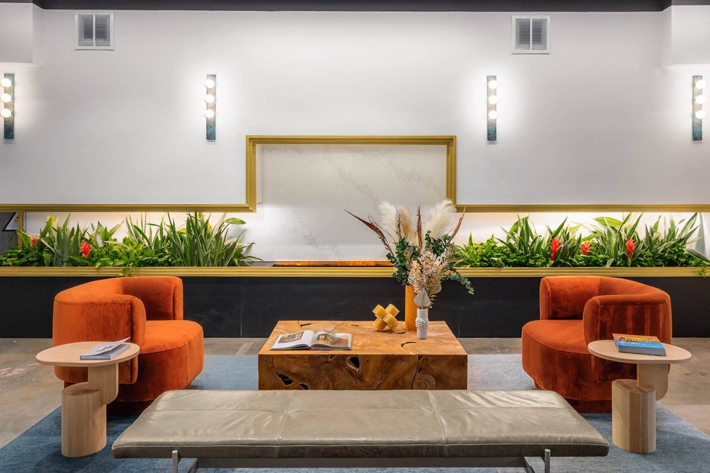 a living room with orange chairs and a coffee table