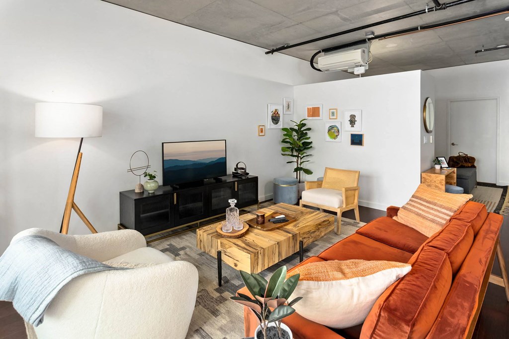 a living room with a orange couch and a tv