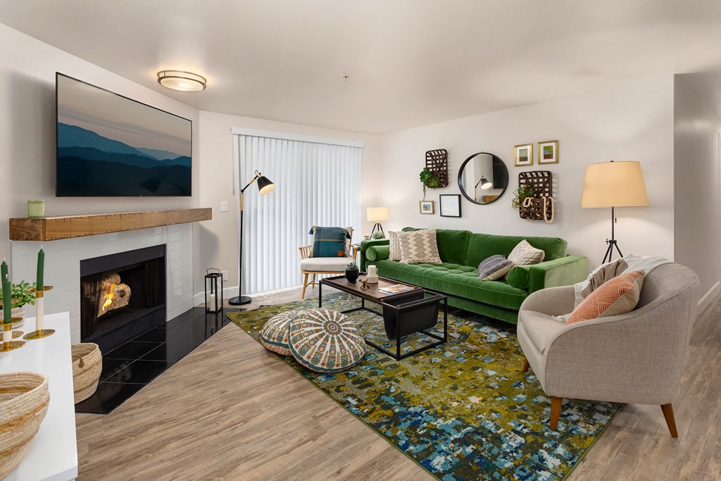 a living room with a green couch and a fireplace