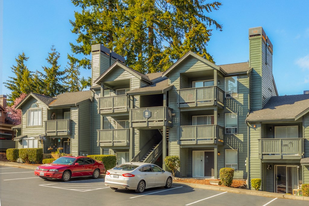 an apartment building with cars parked in front of it