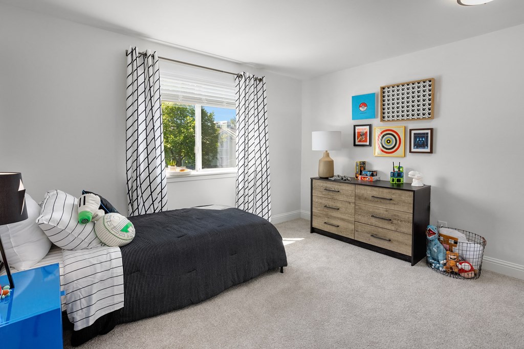 a bedroom with a bed and a dresser and a window