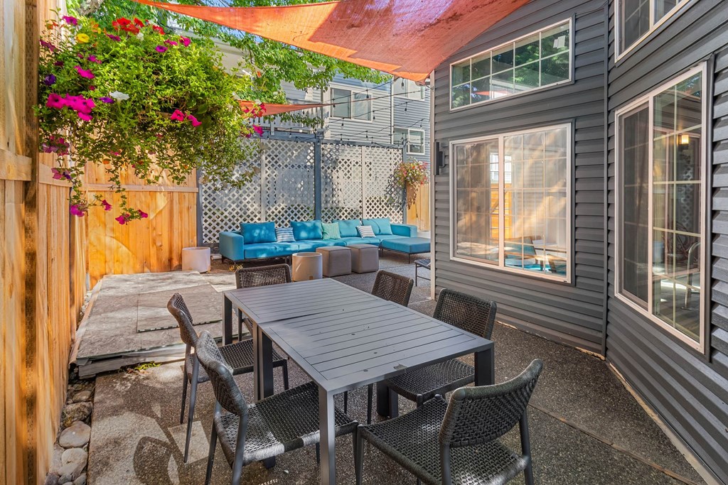 A patio with a table and chairs under a striped awning.