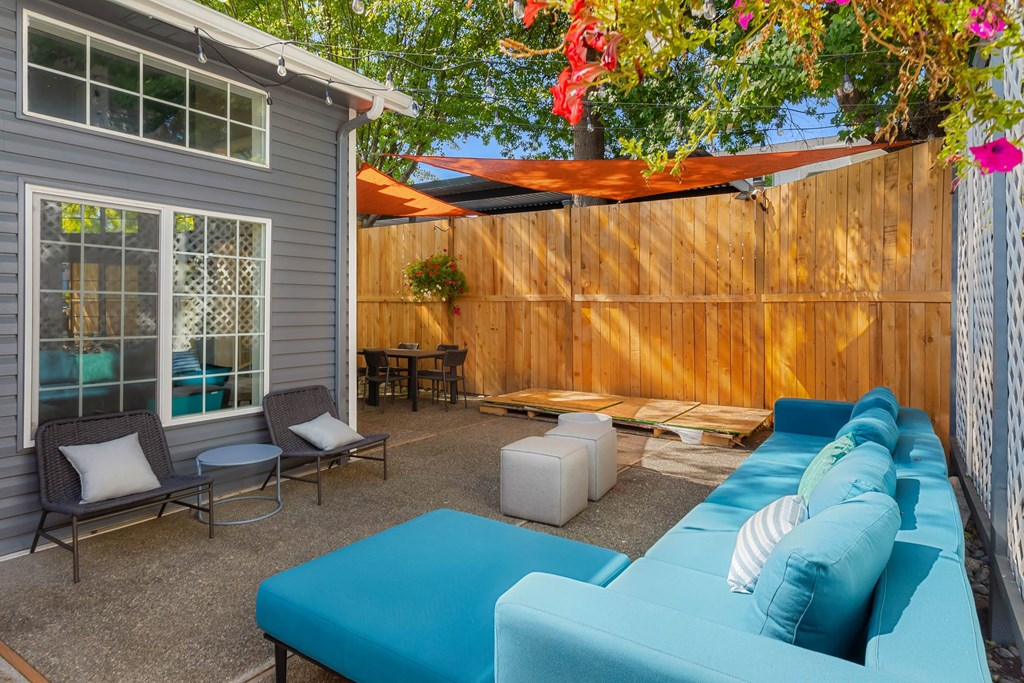 A blue couch is in the center of a patio.