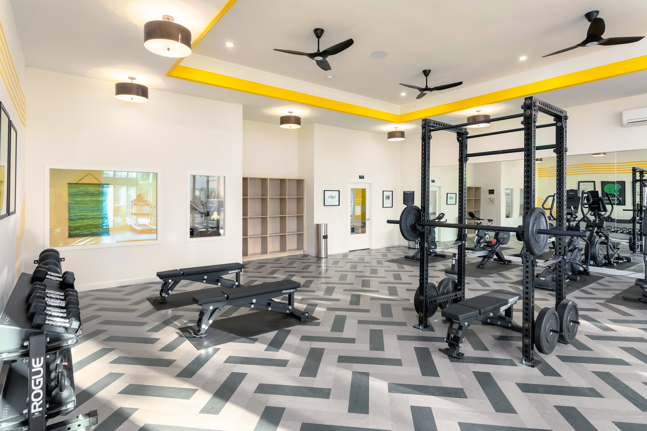 a gym with weights machines and paintings on the wall