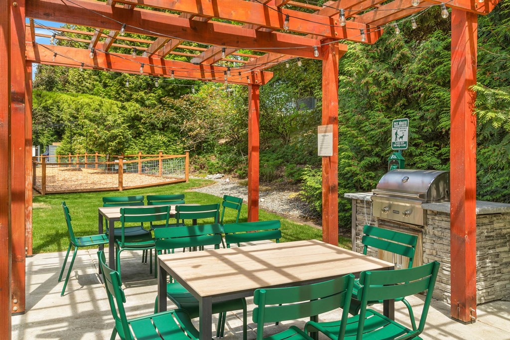 a patio with a pergola and tables and chairs